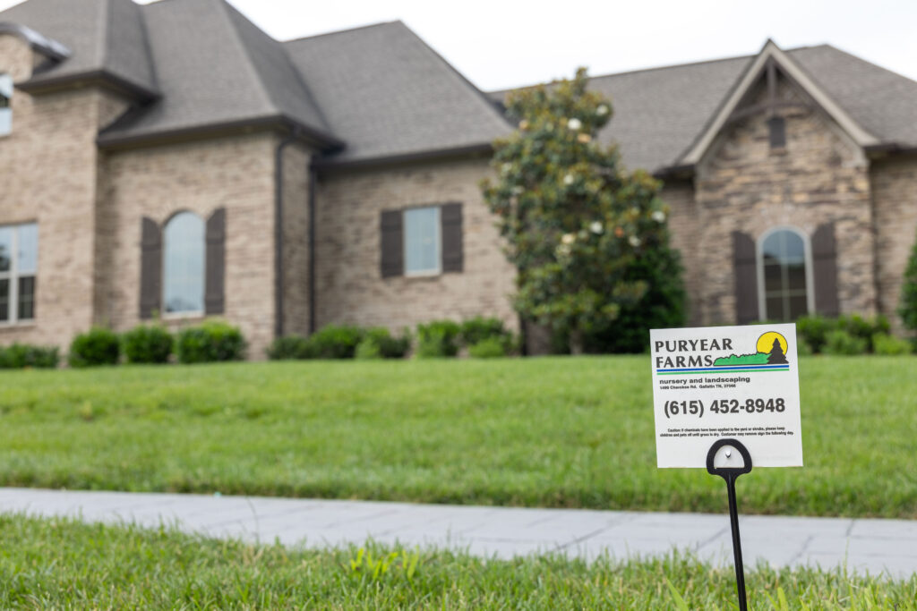 Puryear Farms lawn care leave-behind sign placed in a freshly treated residential lawn in Sumner County, TN indicating service completion.